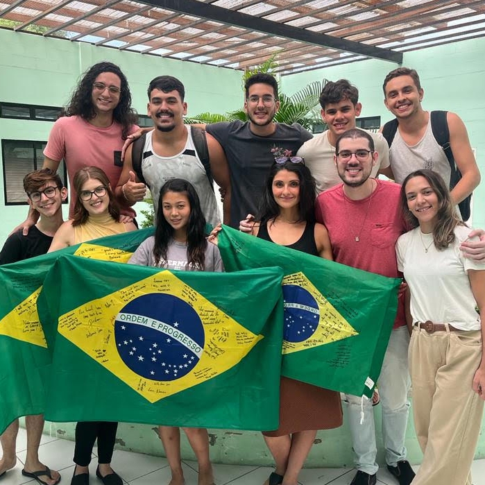 A group of people holding Brazil Flags standing in a group